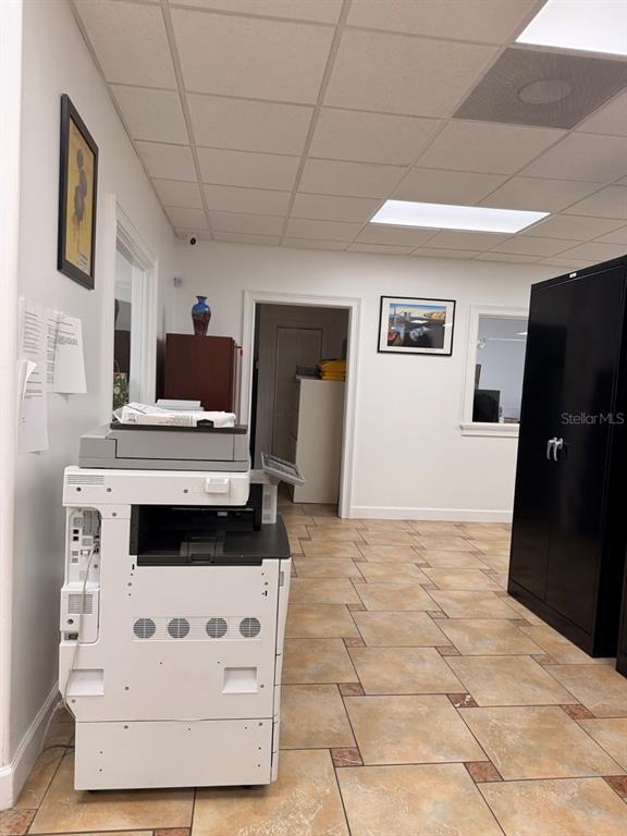 An office space features a large printer, a black metal cabinet, and tiled flooring — 7117 N ARMENIA AVENUE, TAMPA, FL