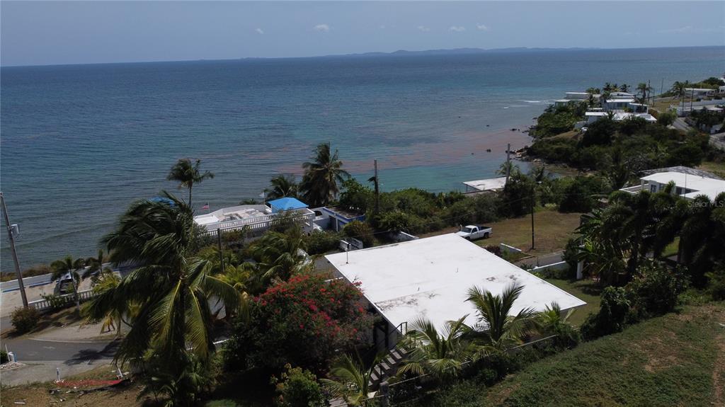 An aerial view shows a white-roofed house near a coastline with palm trees and ocean — 398 CASA CORAZON, VIEQUES, PR