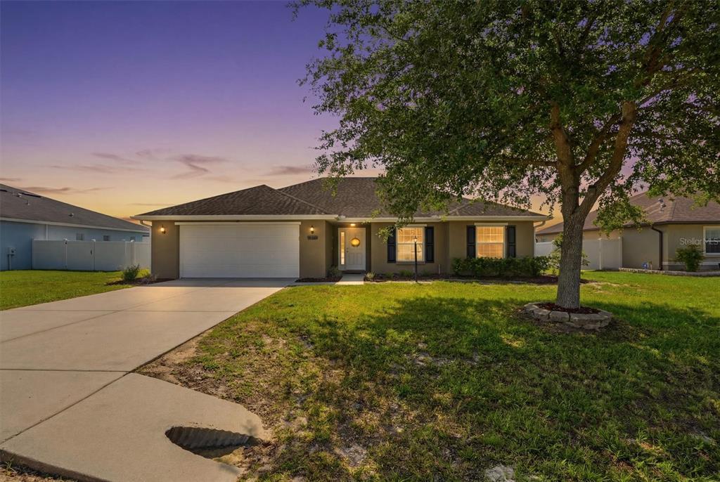 A single-story suburban house with a two-car garage and a large tree in the yard — 9917 SW 51ST COURT, OCALA, FL