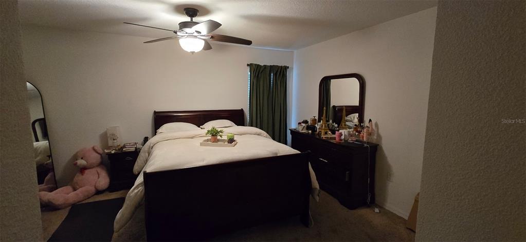 An open-concept living area features light tile flooring, a ceiling fan, and a kitchen island — 1528 E FALMOUTH AVENUE, DELTONA, FL