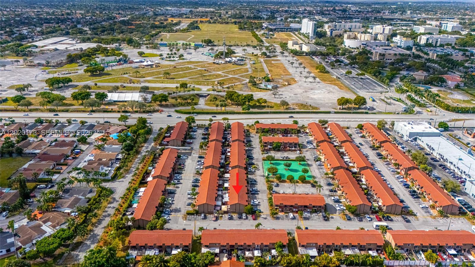 An aerial view shows a residential complex with red-tiled roofs and a central parking area — 1911 SW 107th Ave # 1009, Miami FL 33165, MIAMI, FL