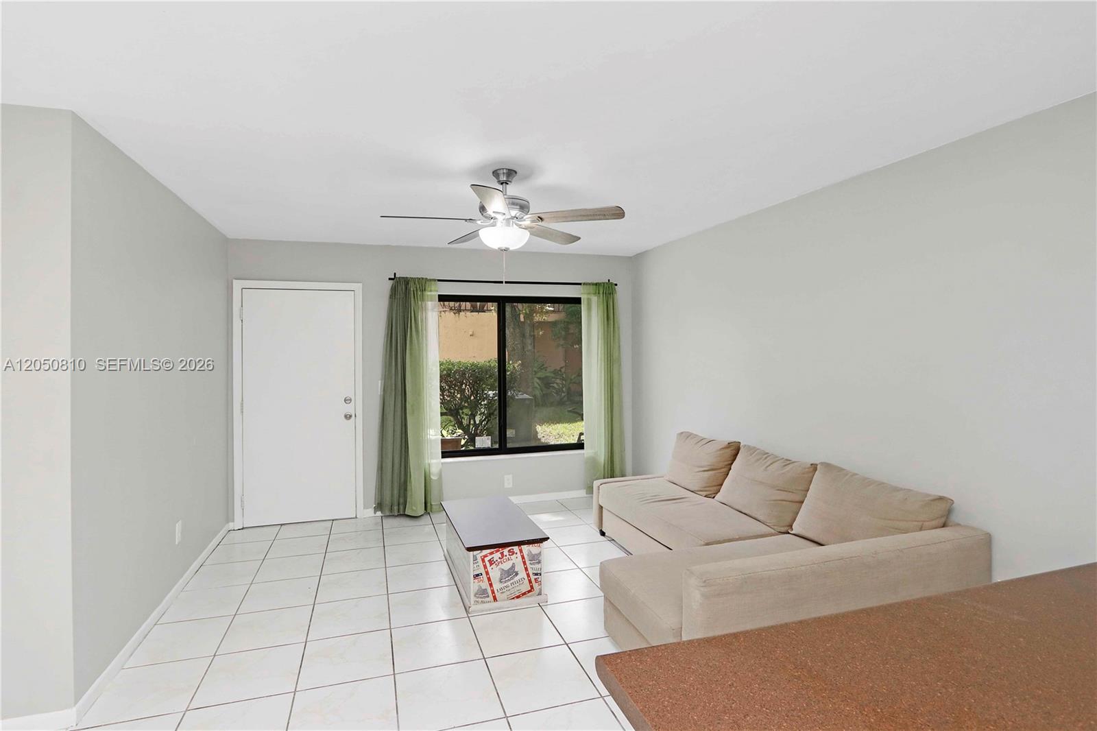 A living room features light tile flooring, a beige sectional sofa, and a ceiling fan — 2530 W 67th Pl # 29, Hialeah FL 33016, HIALEAH, FL