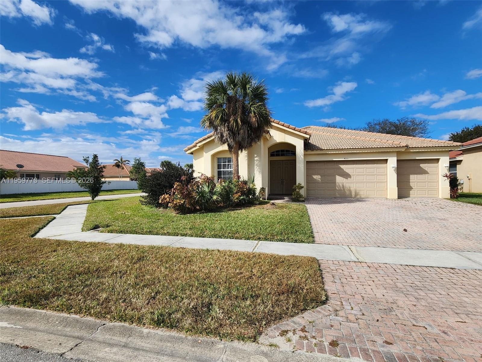 A single-story house with a beige exterior, a tiled roof, and a paved driveway — 4155 Worlington Ter, Fort Pierce FL 34947, FORT PIERCE, FL