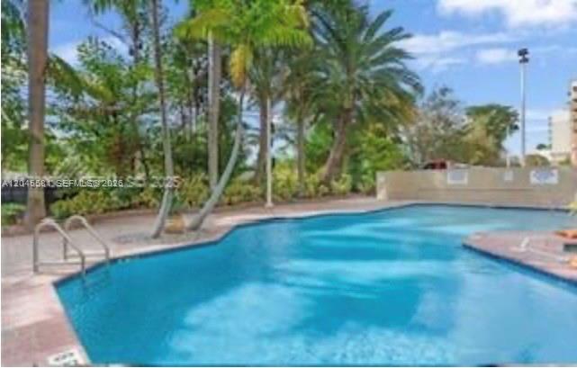 An outdoor swimming pool surrounded by palm trees and lush landscaping — 3500 Coral Way # 513, Miami FL 33145, MIAMI, FL