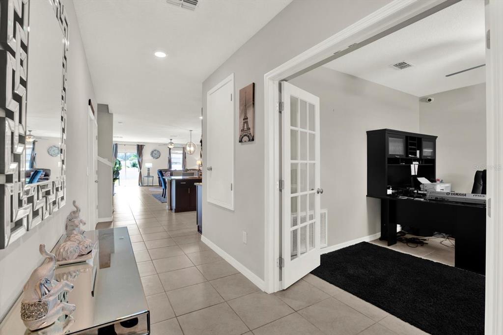 A tiled hallway leads to an open living area with a home office on the right — 13524 WILD GINGER STREET, RIVERVIEW, FL