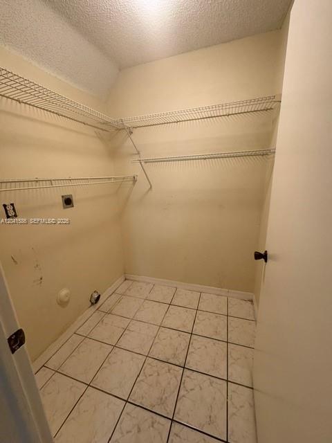 A small, empty utility closet with white tiled floors, wall-mounted wire shelving, and beige walls — 3690 SW 153rd Pl, Miami FL 33185, MIAMI, FL