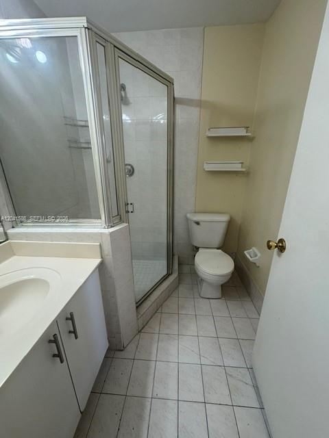 A bathroom features a glass-enclosed shower, a white vanity, a toilet, and tiled flooring — 3690 SW 153rd Pl, Miami FL 33185, MIAMI, FL