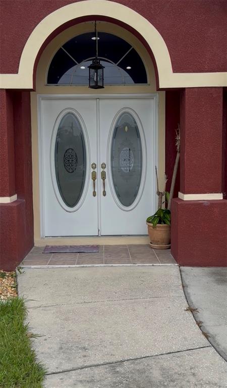 A front entryway features white double doors with oval glass inserts under an arched portico — 4470 GONDOLIER ROAD, SPRING HILL, FL