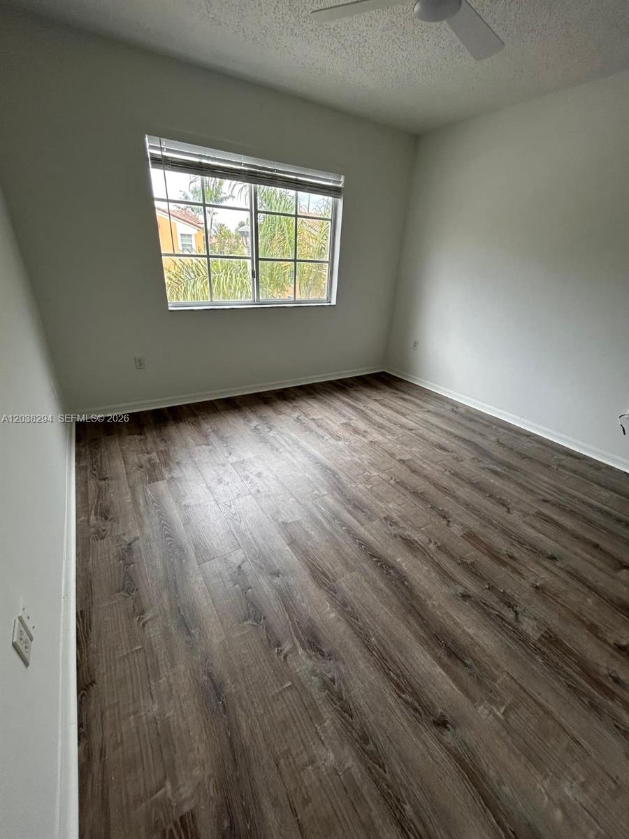 An empty bedroom features wood-look flooring, white walls, and a window with blinds — 2440 E Preserve Way # 303, Miramar FL 33025, MIRAMAR, FL