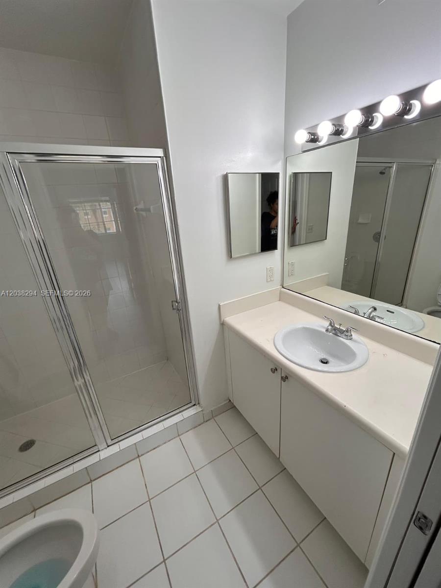A bathroom features a white vanity, a glass-enclosed shower, and a large wall mirror — 2440 E Preserve Way # 303, Miramar FL 33025, MIRAMAR, FL