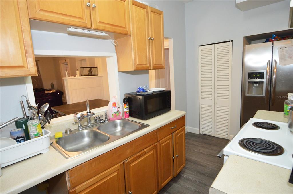A kitchen features wood cabinets, a double-basin sink, a microwave, and stainless steel appliances — 1244 20TH AVENUE S, ST PETERSBURG, FL