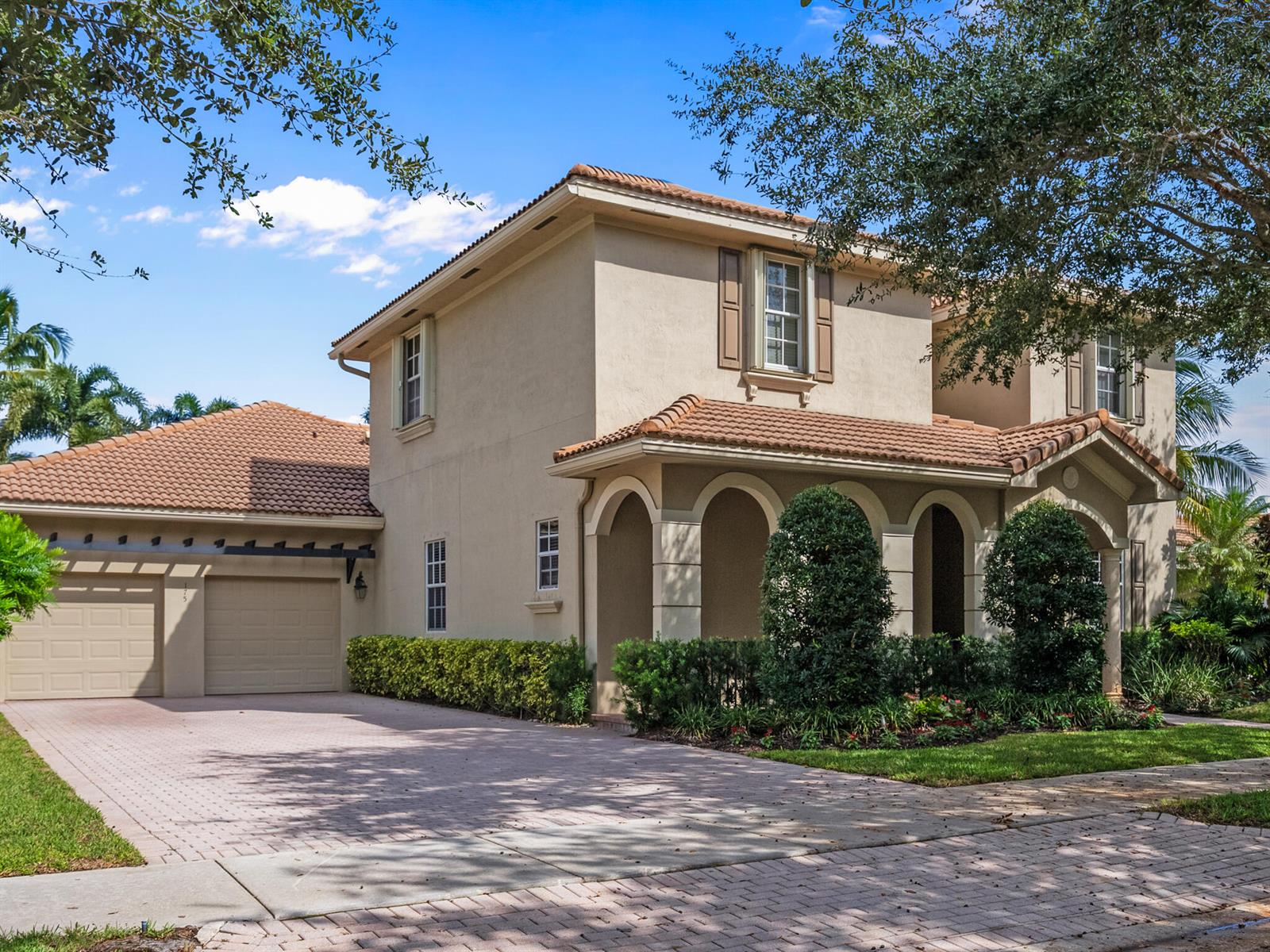 A two-story stucco house with a tile roof, arched front porch, and a paved driveway — 175 Via Rosina, Jupiter FL 33458, JUPITER, FL