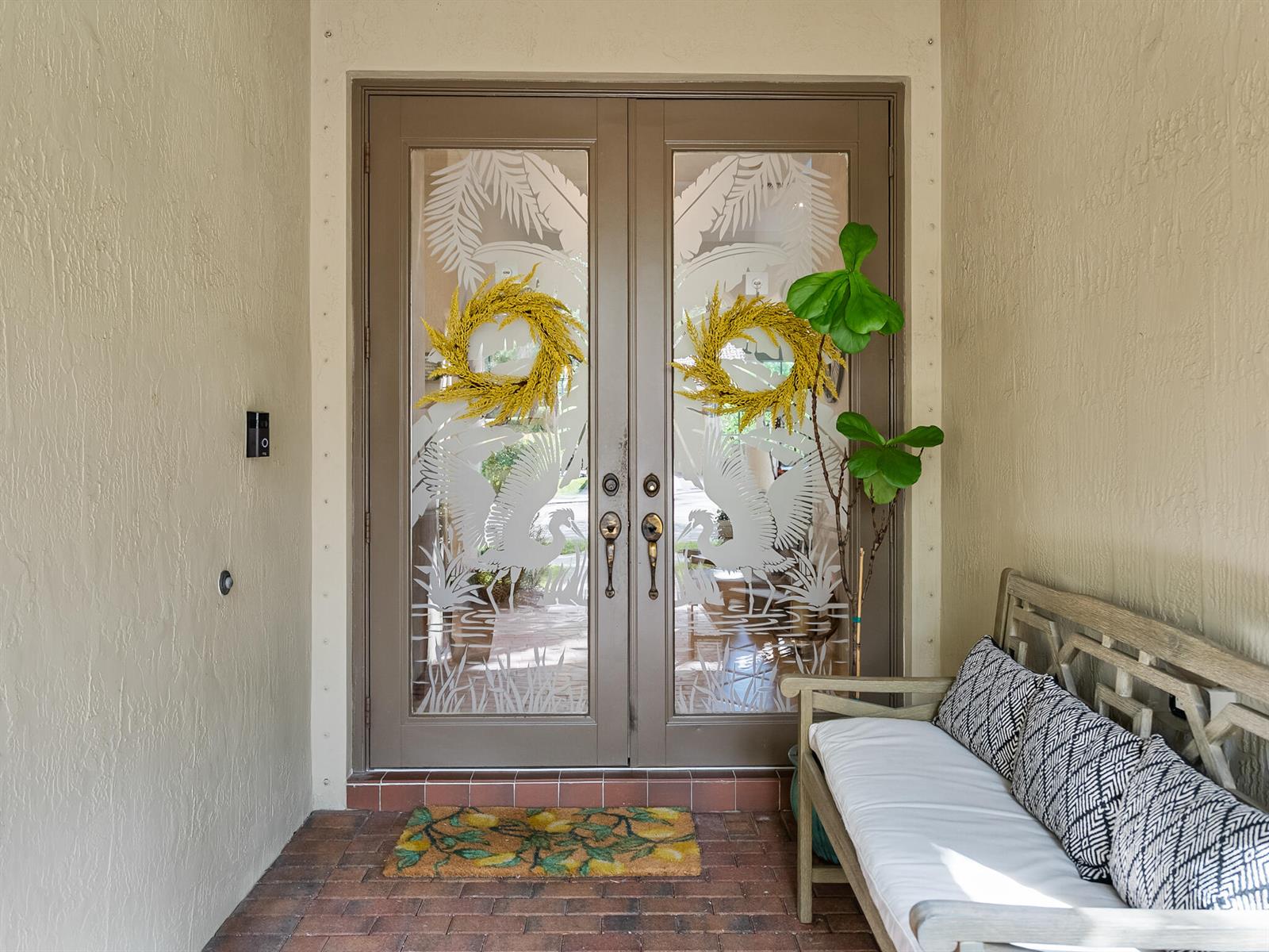 A front entryway features double glass doors with etched heron designs, yellow wreaths, and a bench — 175 Via Rosina, Jupiter FL 33458, JUPITER, FL