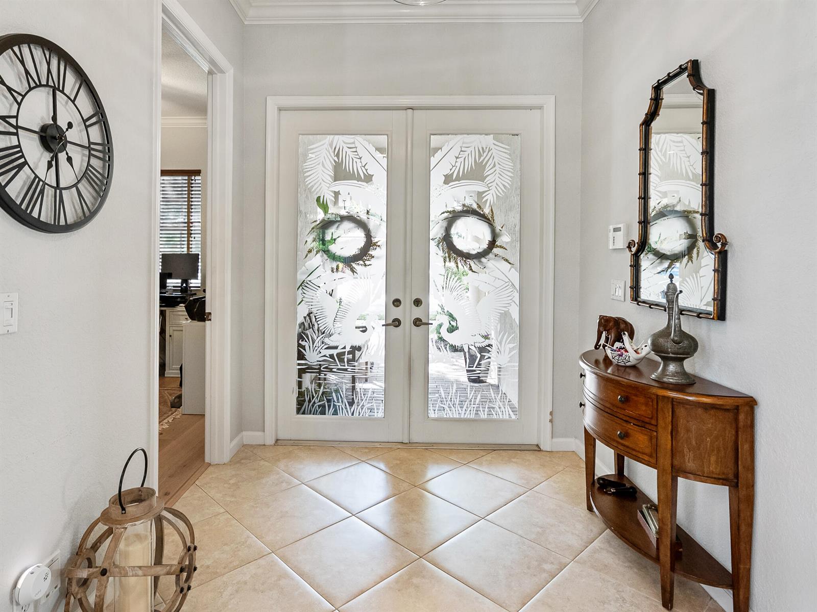 A foyer features tile flooring, double glass doors with etched designs, and a wooden console table — 175 Via Rosina, Jupiter FL 33458, JUPITER, FL