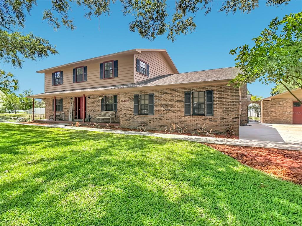 A two-story house with a brick facade, brown siding, and a front porch — 3465 JAMIE STREET, MULBERRY, FL