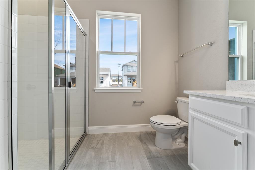 A bathroom features a glass-enclosed shower, a toilet, a vanity, and a window — 13254 MCMILLAN DRIVE, ORLANDO, FL