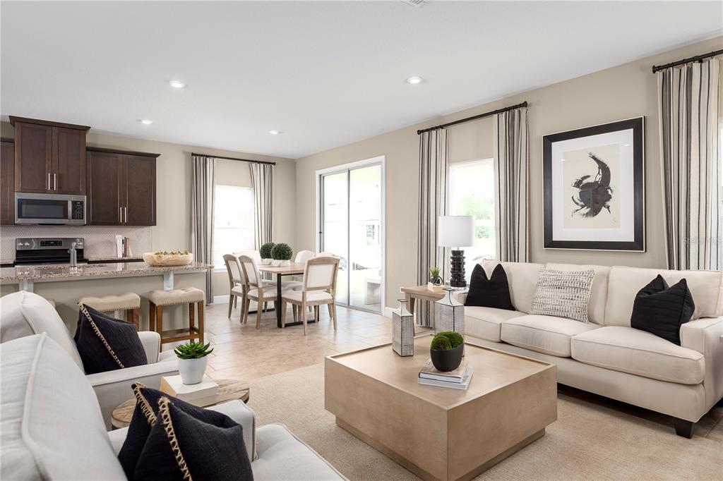 An open-concept living and dining area features a kitchen with dark cabinetry and tile flooring — 7388 SW 107TH LANE, OCALA, FL