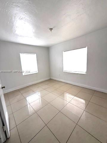 An empty bedroom features white walls, a light-colored tiled floor, and two windows — 760 SE 7th Ave # 760, Hialeah FL 33010, HIALEAH, FL