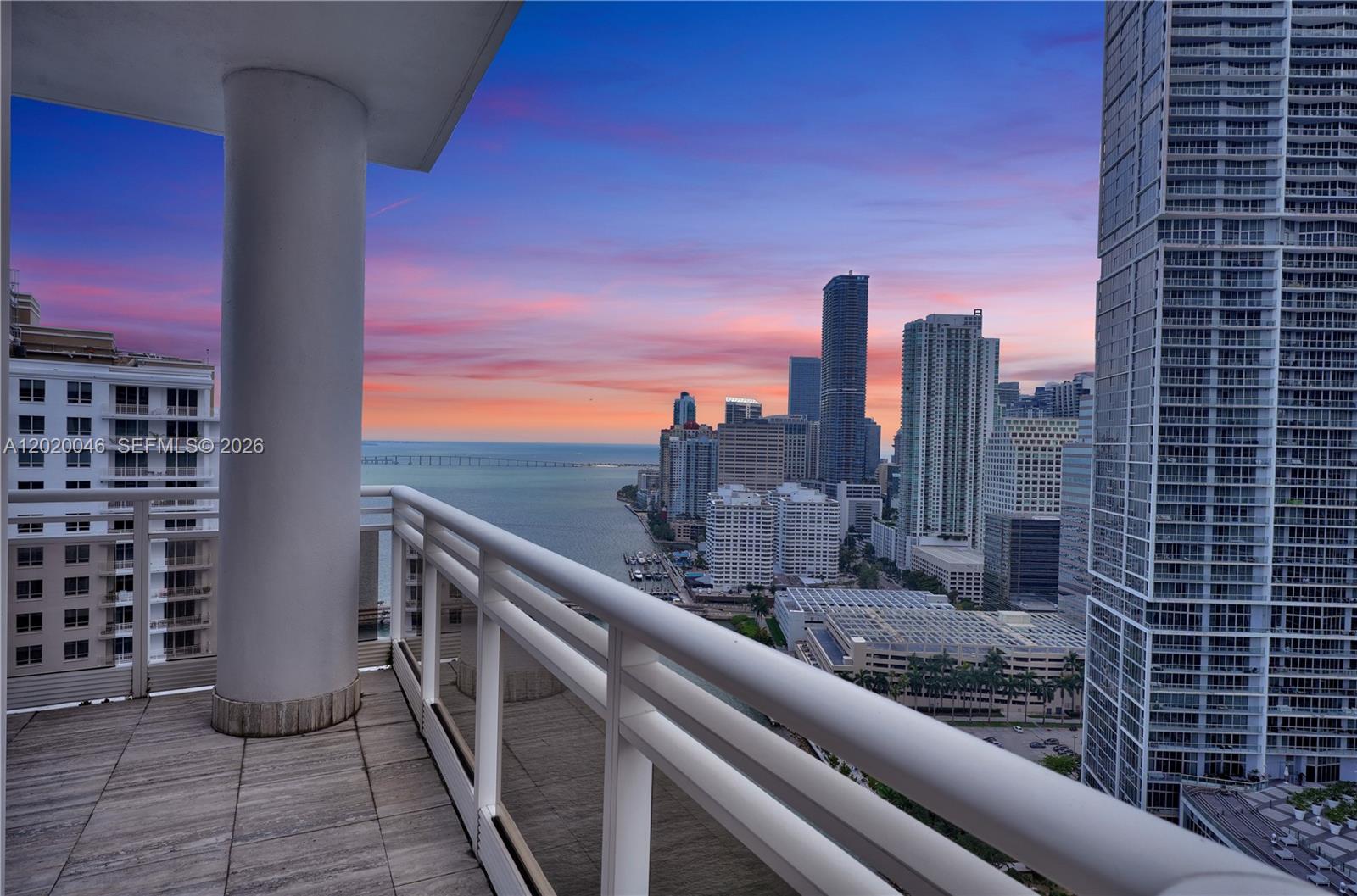 A balcony with a white railing overlooks a city skyline and a body of water — 901 Brickell Key Blvd # 3204, Miami FL 33131, MIAMI, FL
