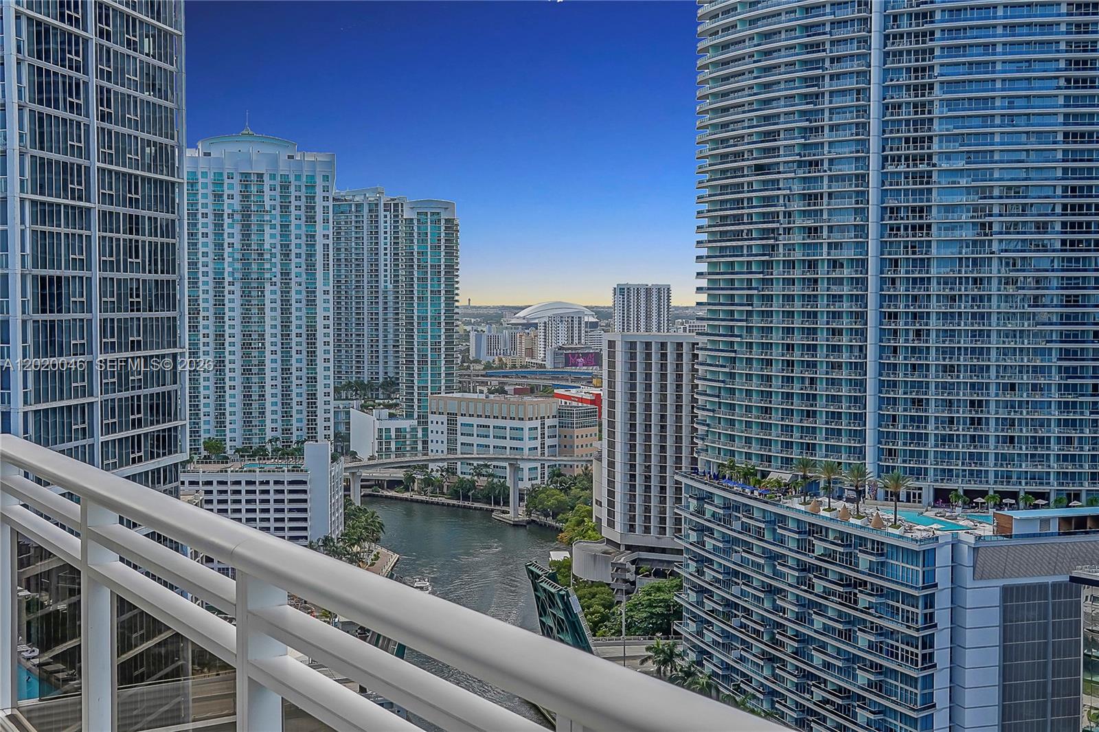 A high-rise balcony overlooks a river, a bridge, and surrounding urban skyscrapers in Miami — 901 Brickell Key Blvd # 3204, Miami FL 33131, MIAMI, FL