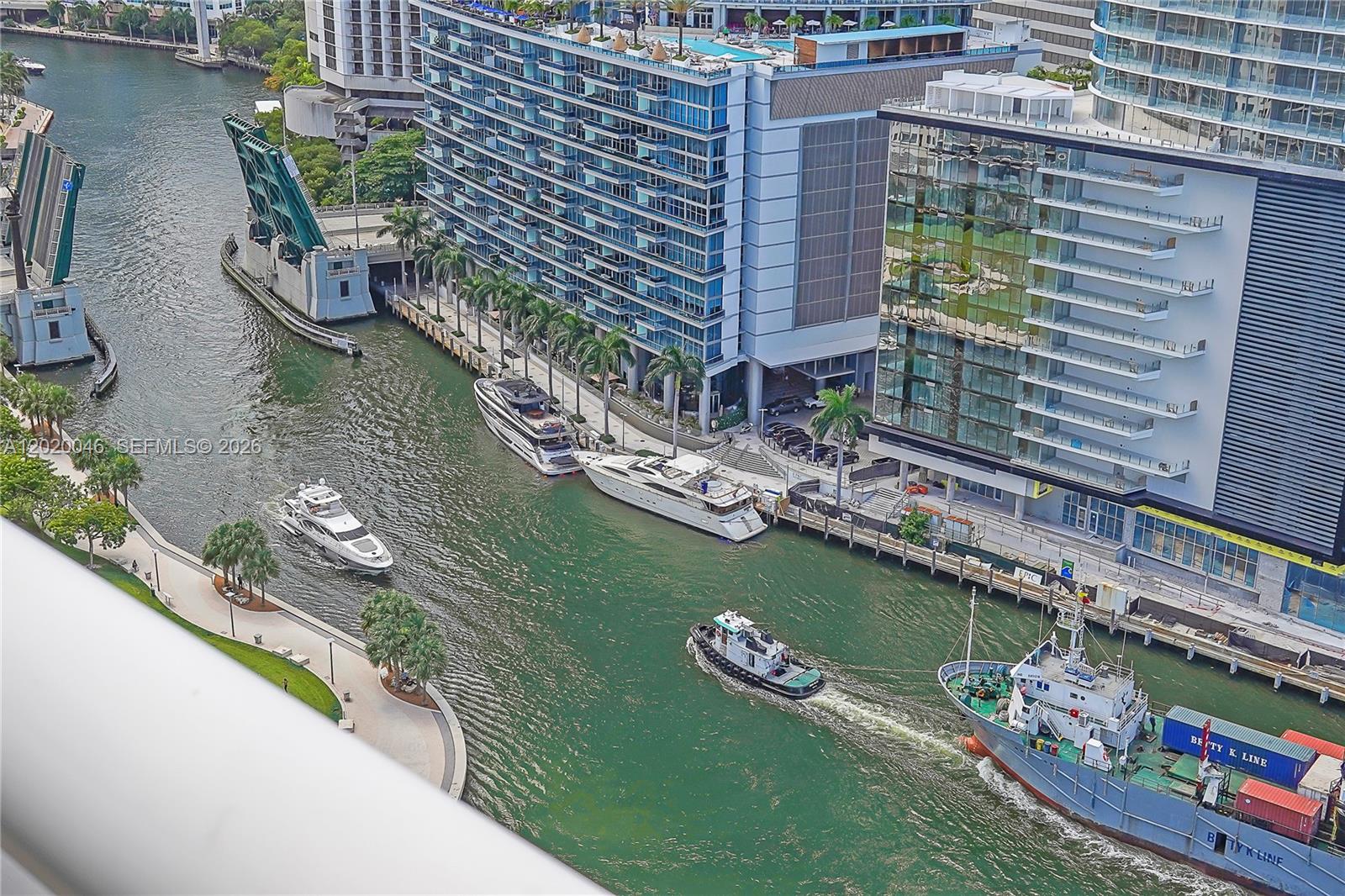 An aerial view shows a canal with boats, a drawbridge, and modern high-rise buildings — 901 Brickell Key Blvd # 3204, Miami FL 33131, MIAMI, FL