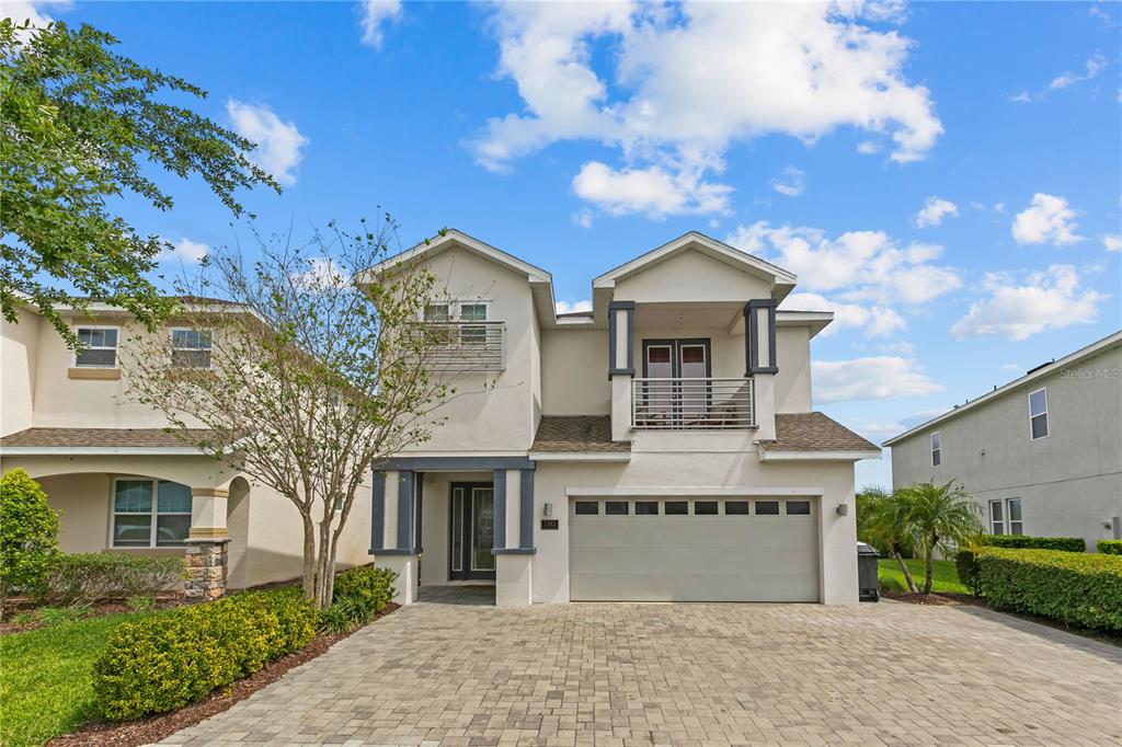 A two-story house with a paved driveway, a two-car garage, and a second-floor balcony — 7483 MARKER AVENUE, KISSIMMEE, FL
