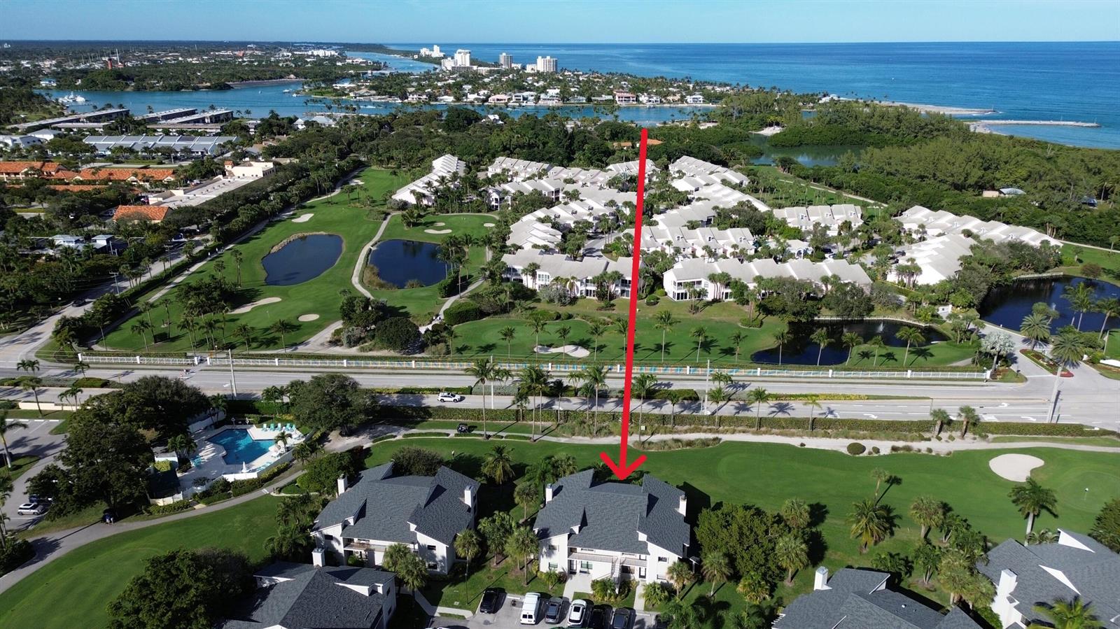 An aerial view shows a residential building complex situated on a golf course near water — 404 Clubhouse Circle, Jupiter FL 33477, JUPITER, FL