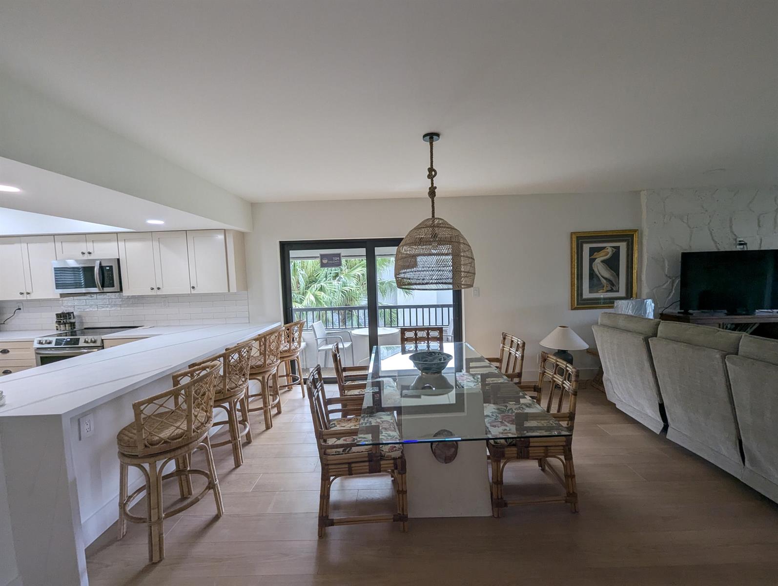 A kitchen with a breakfast bar and dining area featuring rattan furniture and tile floors — 404 Clubhouse Circle, Jupiter FL 33477, JUPITER, FL