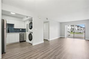 A kitchen with white cabinets and a laundry closet opens to a living area — 3244 NW 84th Avenue, Sunrise FL 33351, SUNRISE, FL