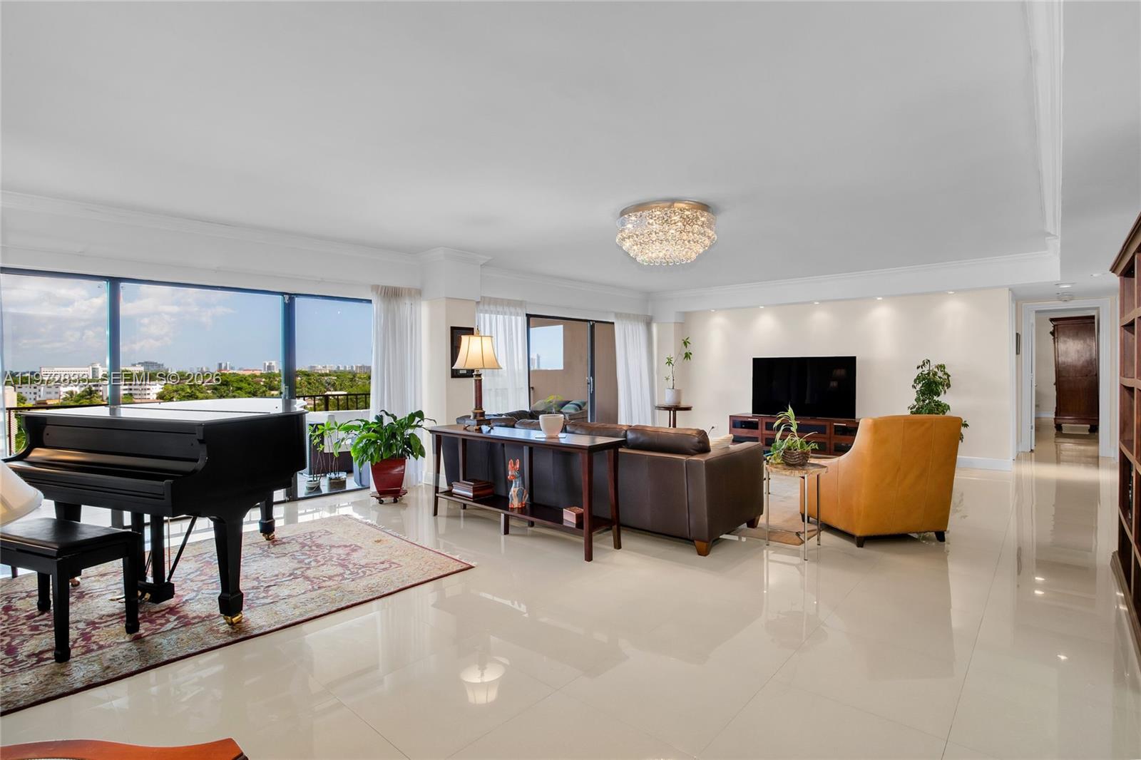 A spacious living room features a grand piano, leather sofa, and large floor-to-ceiling windows — 1800 NE 114th St # 711, Miami FL 33181, MIAMI, FL