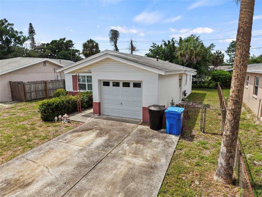 A single-story house with a white concrete block exterior, a garage, and a concrete driveway — 1735 MISSISSIPPI AVENUE NE, ST PETERSBURG, FL