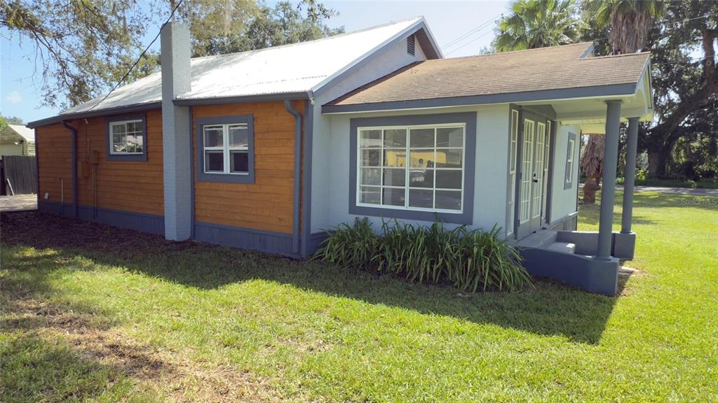 A single-story house with a metal roof, wood siding, and a covered front porch — 14740 JOHNS ROAD, DADE CITY, FL