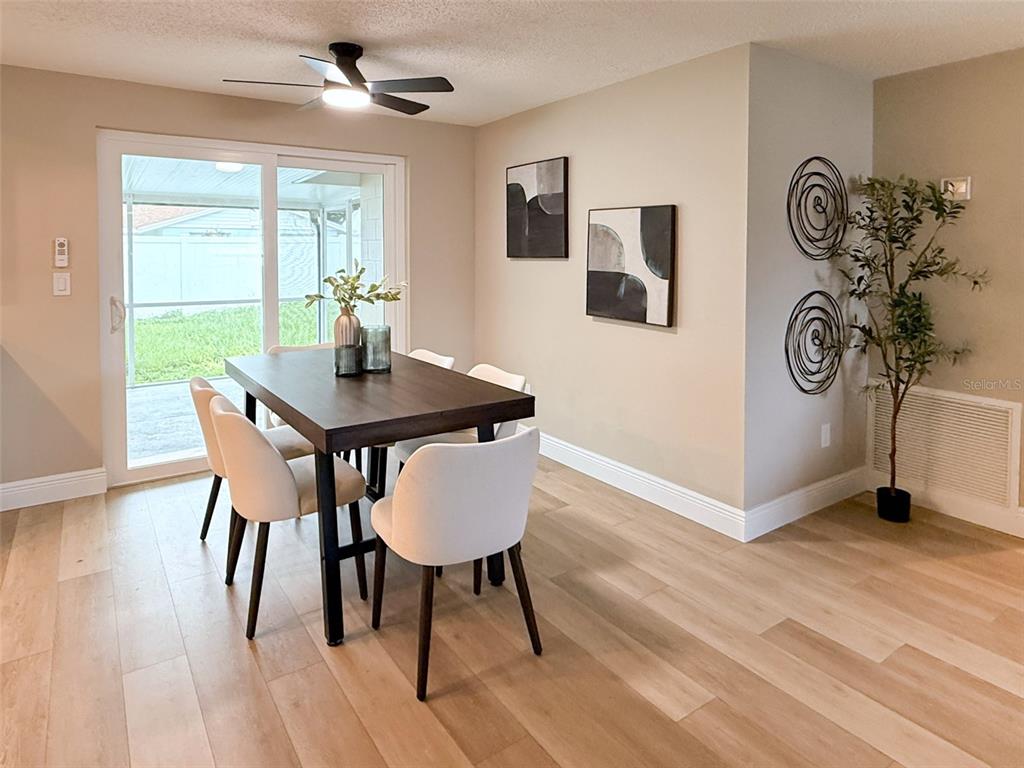 A dining room features a dark wood table, white chairs, and a sliding glass door — 12635 NICOLE LANE, TAMPA, FL