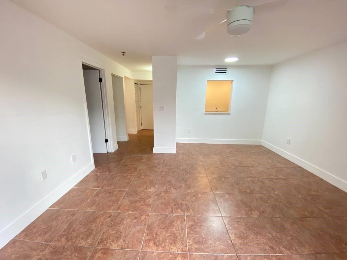 An empty room with brown tile flooring, white walls, and a recessed wall opening — 1740 NW N River Drive # 319, Miami FL 33125, MIAMI, FL