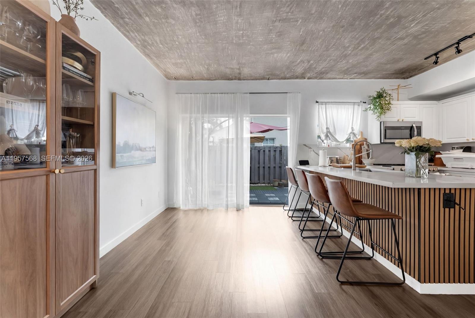 A kitchen features a slatted island, brown bar stools, and a textured concrete ceiling — 5265 NW 112th Ave # 6, Doral FL 33178, DORAL, FL