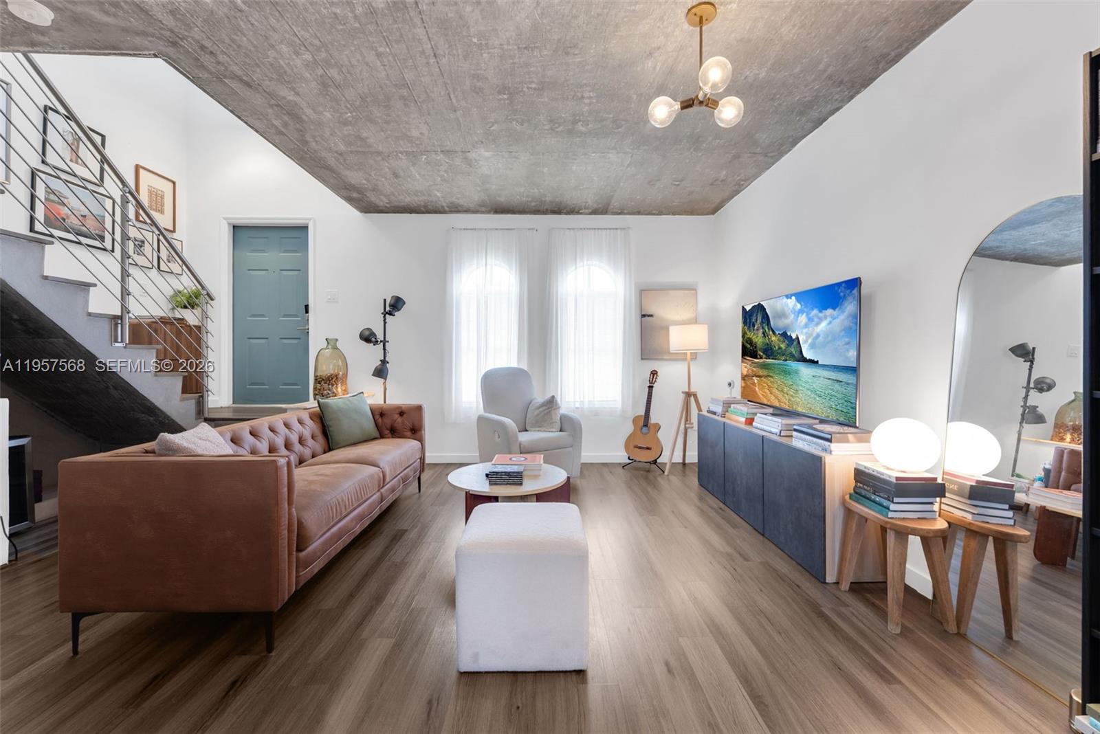 A living room features a tufted leather sofa, concrete ceiling, and a television on a console — 5265 NW 112th Ave # 6, Doral FL 33178, DORAL, FL