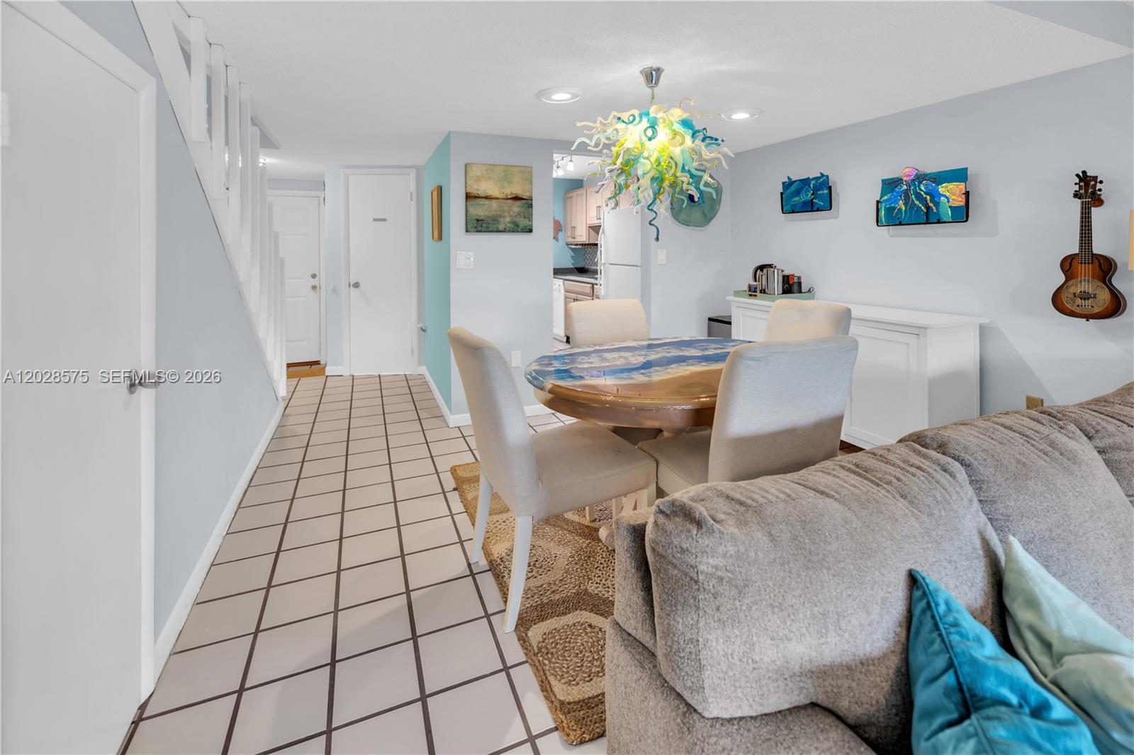 A dining area features a round table, upholstered chairs, and a unique glass chandelier — 40 High Point Rd # 402, Islamorada FL 33070, ISLAMORADA, FL