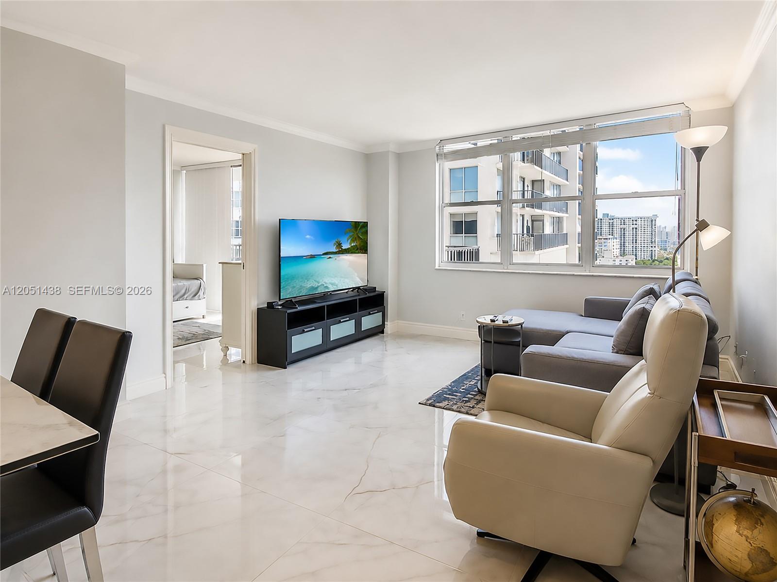 A living room features white marble floors, a grey sectional sofa, and a television console — 2201 S Ocean Dr # 2005, Hollywood FL 33019, HOLLYWOOD, FL