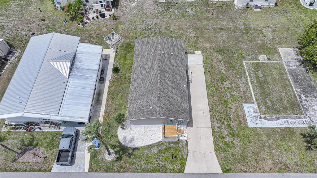 An aerial view shows two adjacent manufactured homes with driveways and a vacant concrete pad — 4810 NW HIGHWAY 72 UNIT 162, ARCADIA, FL