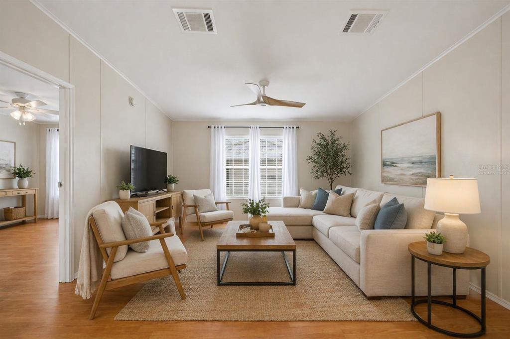 A living room features a sectional sofa, two armchairs, a coffee table, and wood flooring — 4810 NW HIGHWAY 72 UNIT 162, ARCADIA, FL