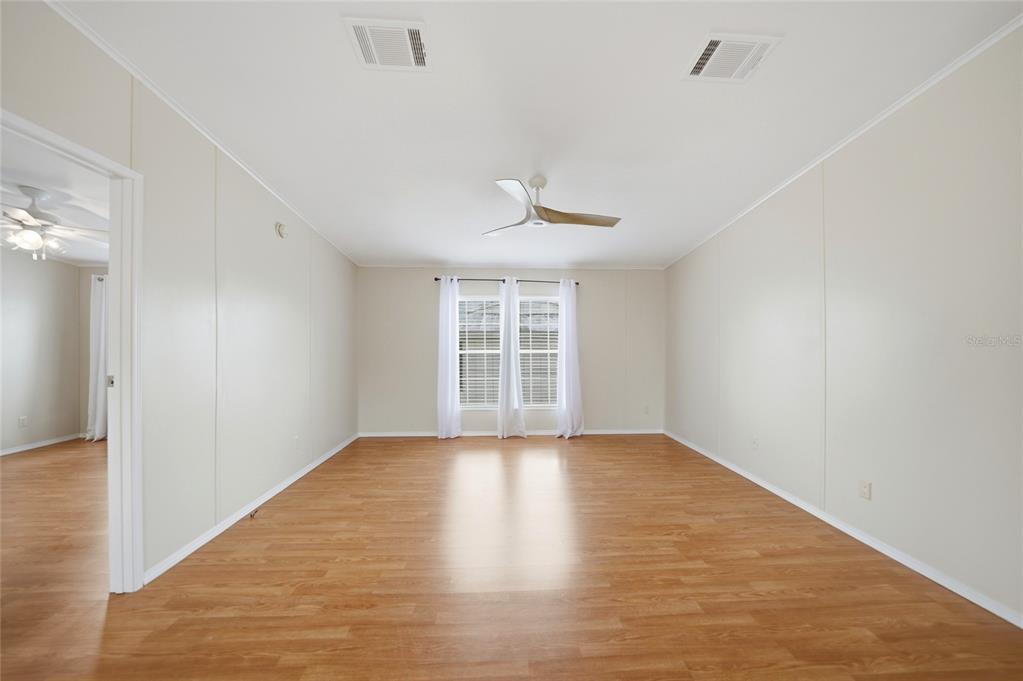 An empty room with light wood-look flooring, white walls, a ceiling fan, and a window — 4810 NW HIGHWAY 72 UNIT 162, ARCADIA, FL