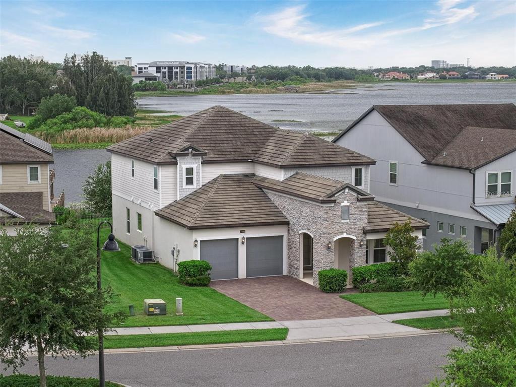 An aerial view of a two-story house with a stone facade and two-car garage — 7446 ALPINE BUTTERFLY LANE, ORLANDO, FL