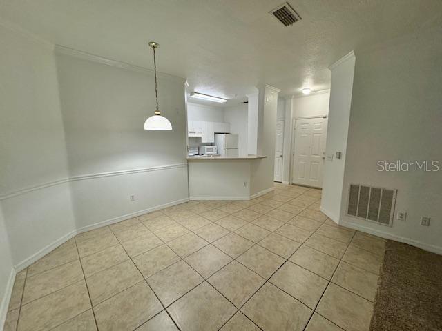 A dining area with tile flooring features a pendant light and an open kitchen — 3611 CONROY UNIT 818, ORLANDO, FL