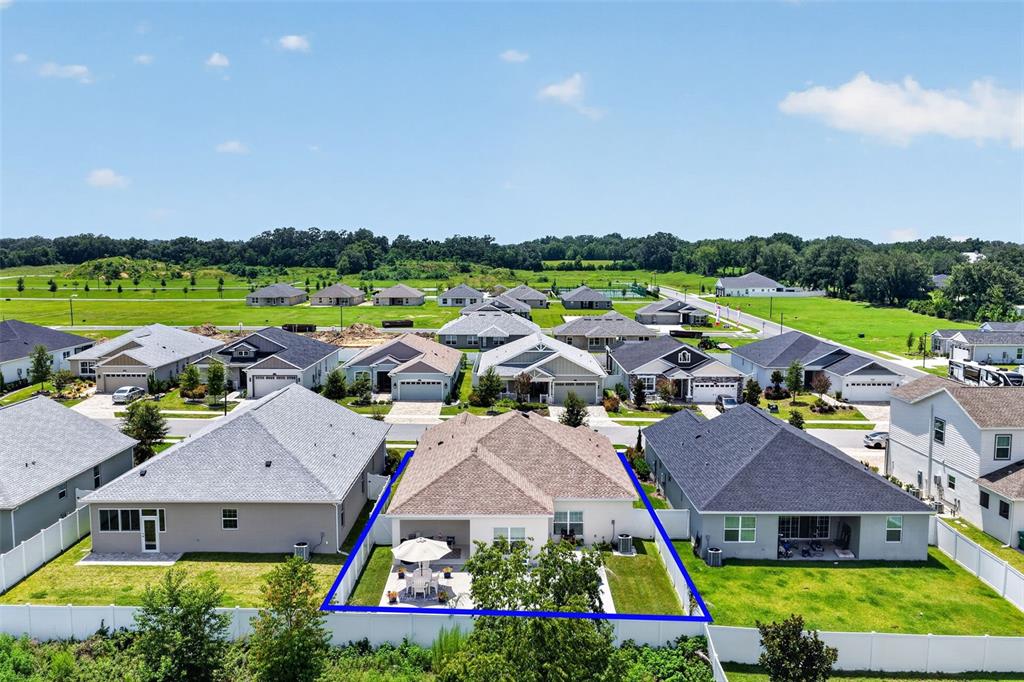 An aerial view shows the back of a suburban house with a fenced yard — 12615 NE 49TH DRIVE, OXFORD, FL