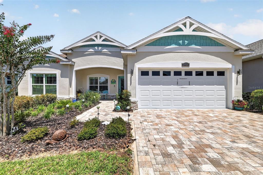 A single-story house with a white garage, a paved driveway, and a landscaped front yard — 12615 NE 49TH DRIVE, OXFORD, FL