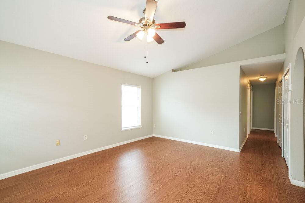 An empty room with light-colored walls, wood-look flooring, and a ceiling fan — 3457 BELLERICAY LANE, LAND O LAKES, FL