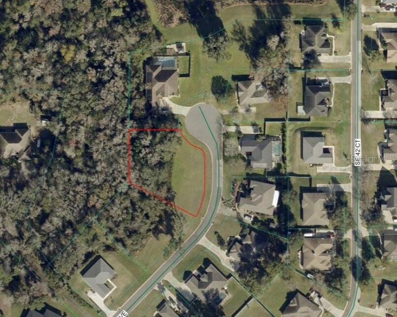 An aerial view shows a vacant residential lot outlined in red within a suburban neighborhood — TBD SE 41ST AVENUE, BELLEVIEW, FL