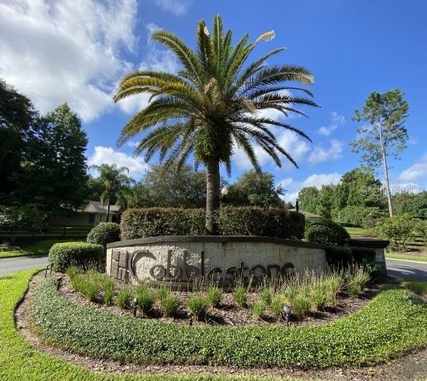 A stone monument sign for Cobblestones sits in front of a large palm tree — TBD SE 41ST AVENUE, BELLEVIEW, FL