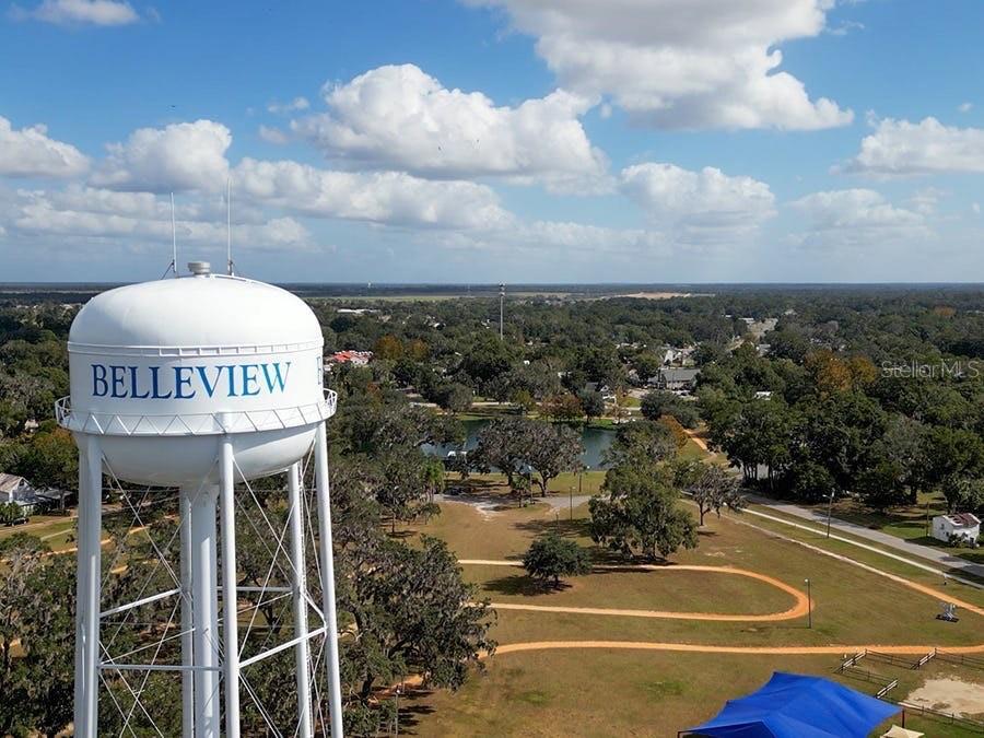 An aerial view shows a white water tower labeled Belleview overlooking a park and pond — TBD SE 41ST AVENUE, BELLEVIEW, FL