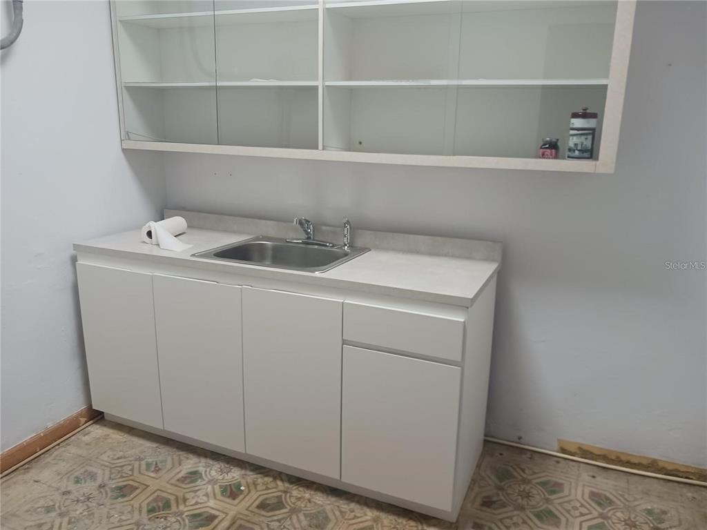 A utility room features white cabinets, a stainless steel sink, and patterned tile flooring — 101 CALLE REINA, PONCE, PR